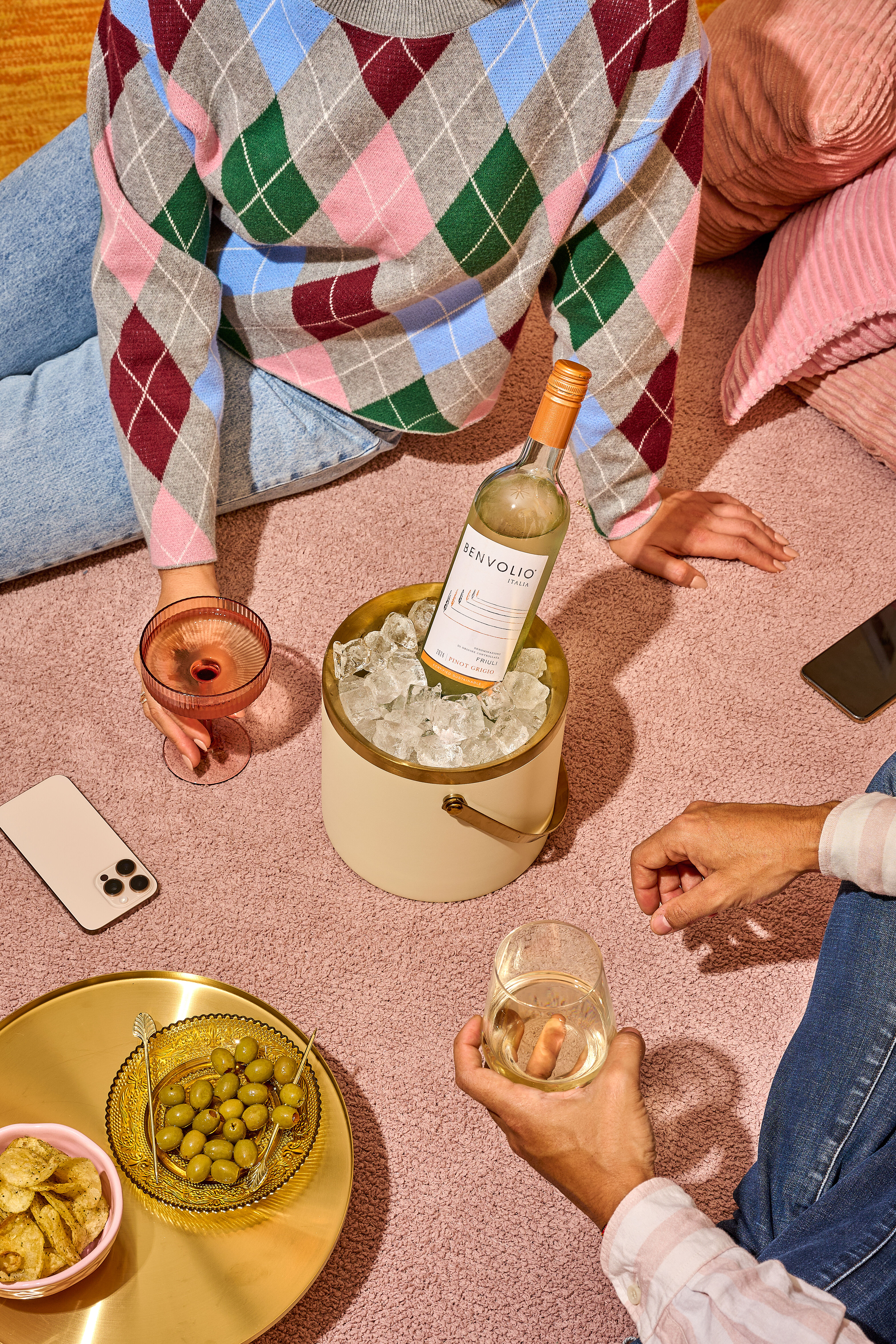 Yellow gingham with three people picnicking and a bottle of Benvolio Prosecco.